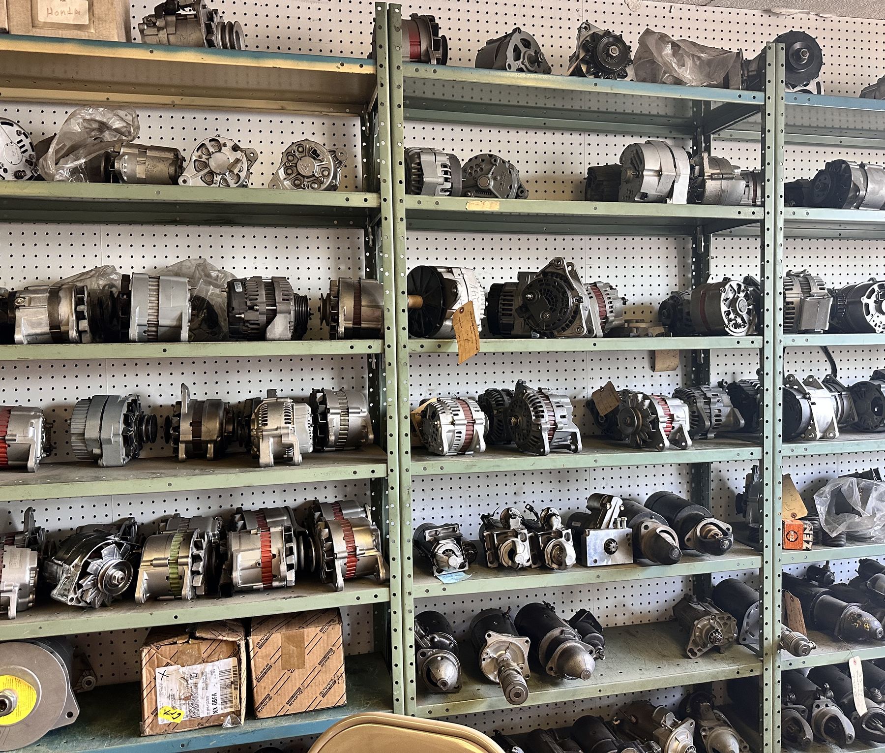 The parts wall at D&D Auto Electric, shelves of rebuilt alternators and starters